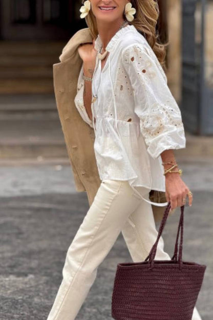 White blouse with a V-neckline and openwork sleeves