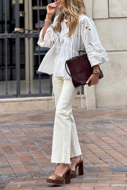White blouse with a V-neckline and openwork sleeves