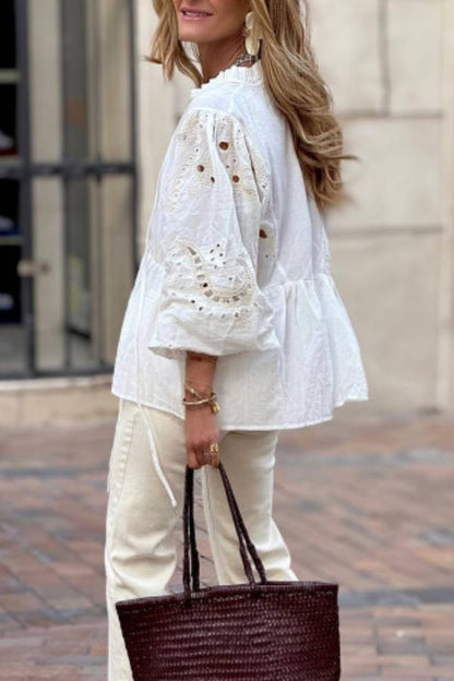 White blouse with a V-neckline and openwork sleeves