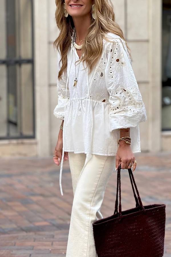 White blouse with a V-neckline and openwork sleeves